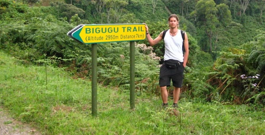 Traveler standing on Mount Bigugu overlooking misty rainforest landscapes in Nyungwe National Park in Rwanda.