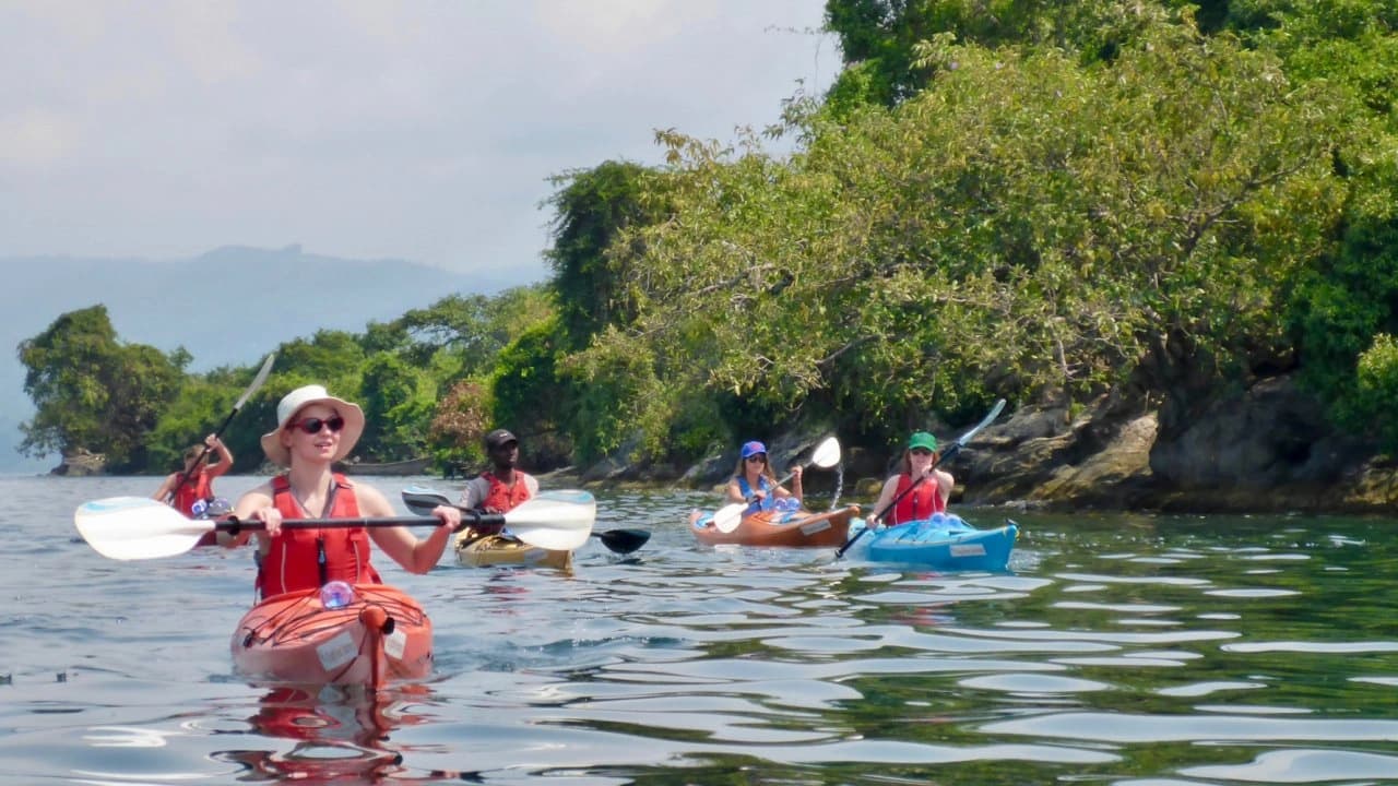 Travelers kayaking on Lake Kivu, Rwanda — adventure tourism and scenic outdoor experience surrounded by lush hills and crystal-clear waters