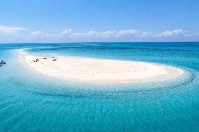 Nakupenda Beach Zanzibar at low tide with crystal-clear turquoise waters, white sandbanks, and traditional wooden boats — How To Visit & Experience Zanzibar: Ultimate Travel Guide.