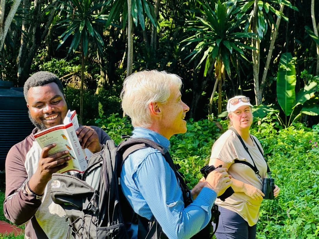 Husband and wife birdwatching with expert guide at Buhanga Eco-Park, exploring the best places for birdwatching in Uganda and Rwanda.