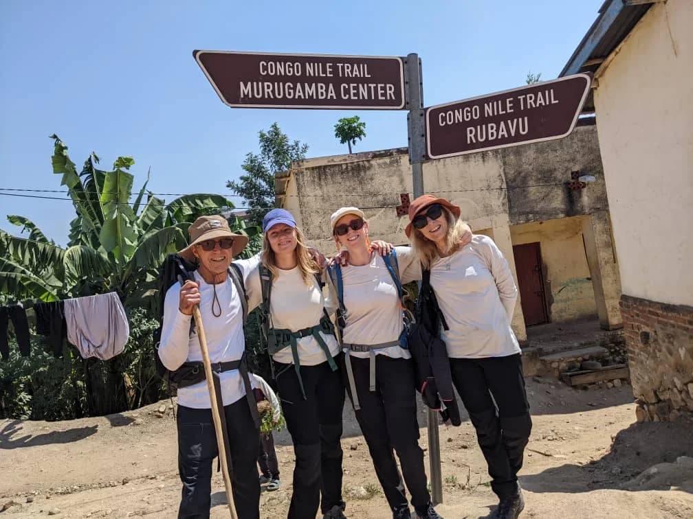 A group of joyful women travelers taking photos before starting their adventure on Rwanda’s iconic Congo Nile Trail.