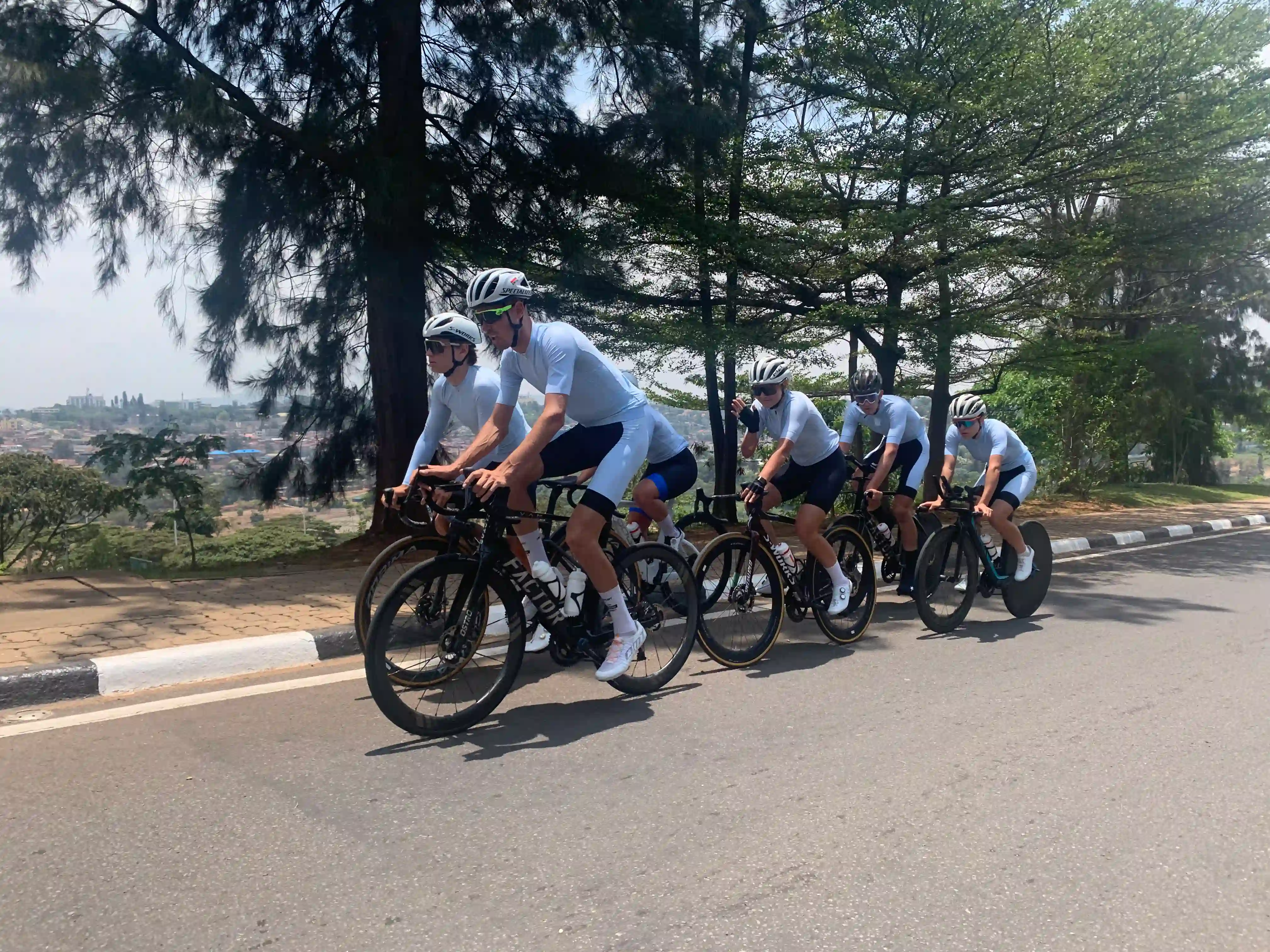 Group of cyclists riding through the clean, green streets of Kigali, Rwanda during guided road cycling tours in Rwanda.