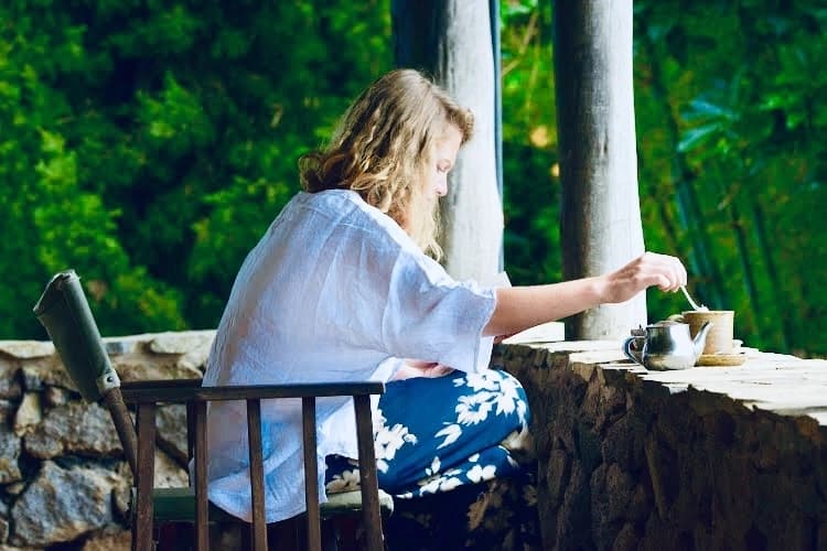 Traveler woman enjoying a luxury eco-lodge breakfast with crispy bacon in Rwanda, surrounded by nature and morning serenity.
