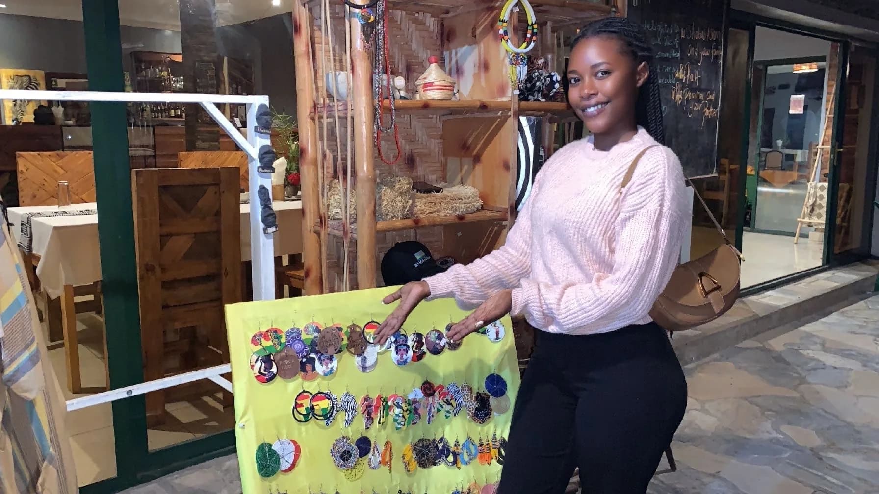 Rwandan girl showcasing handmade crafts at an eco-lodge community shop, illustrating ecotours and impact in Rwanda through local culture and sustainable tourism.