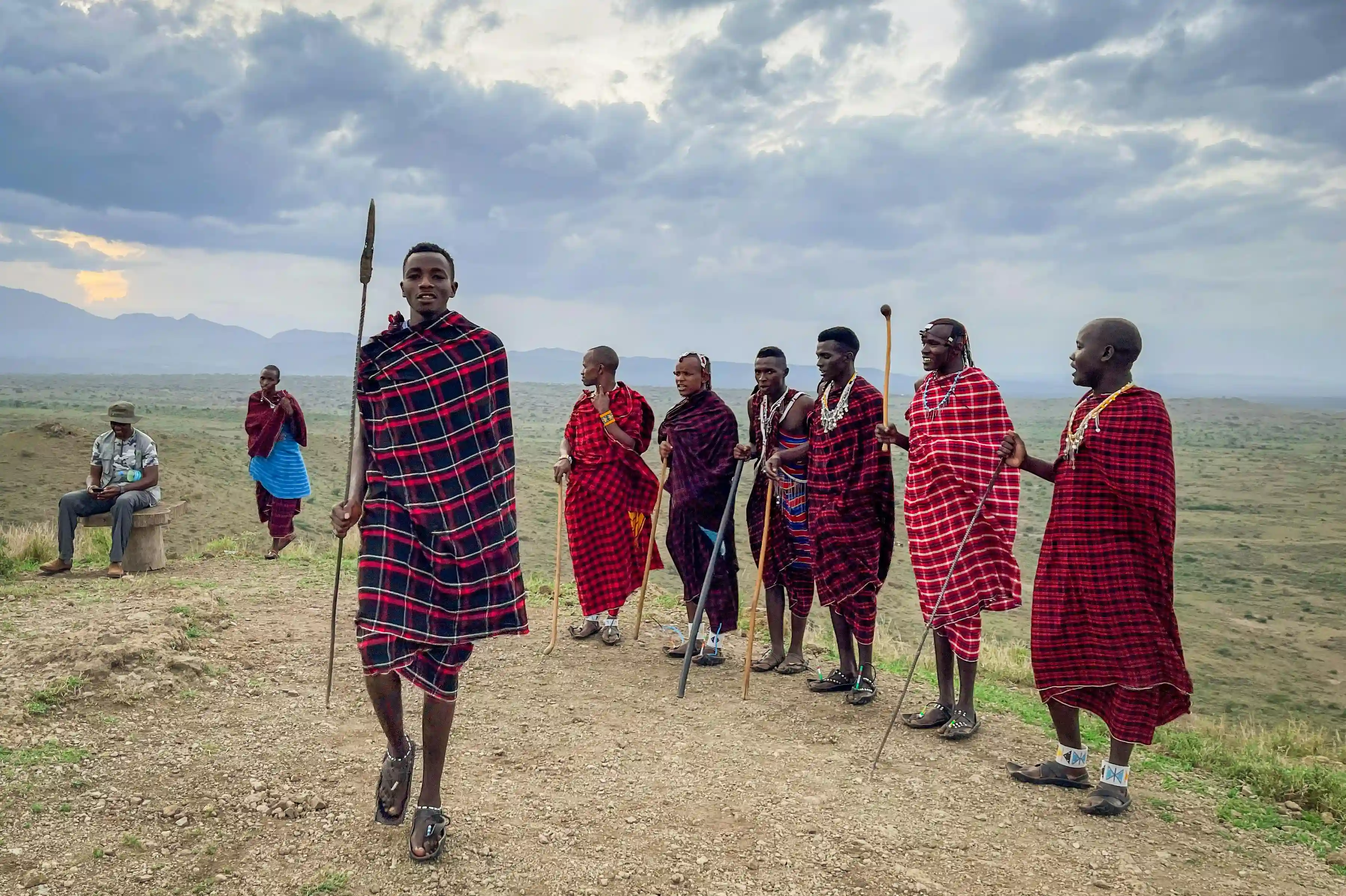 Maasai people dancing in traditional attire in Serengeti National Park, Tanzania, celebrating their rich culture under the African sky.