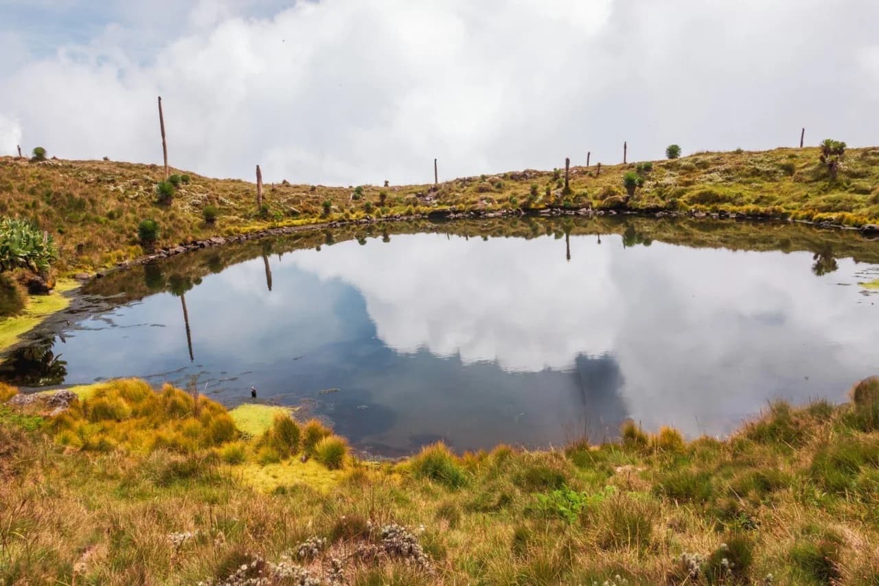 Muhabura Crater Lake view on one of the 10 best hiking tours and trails in Rwanda, showcasing stunning volcanic scenery and peaceful mountain landscapes.