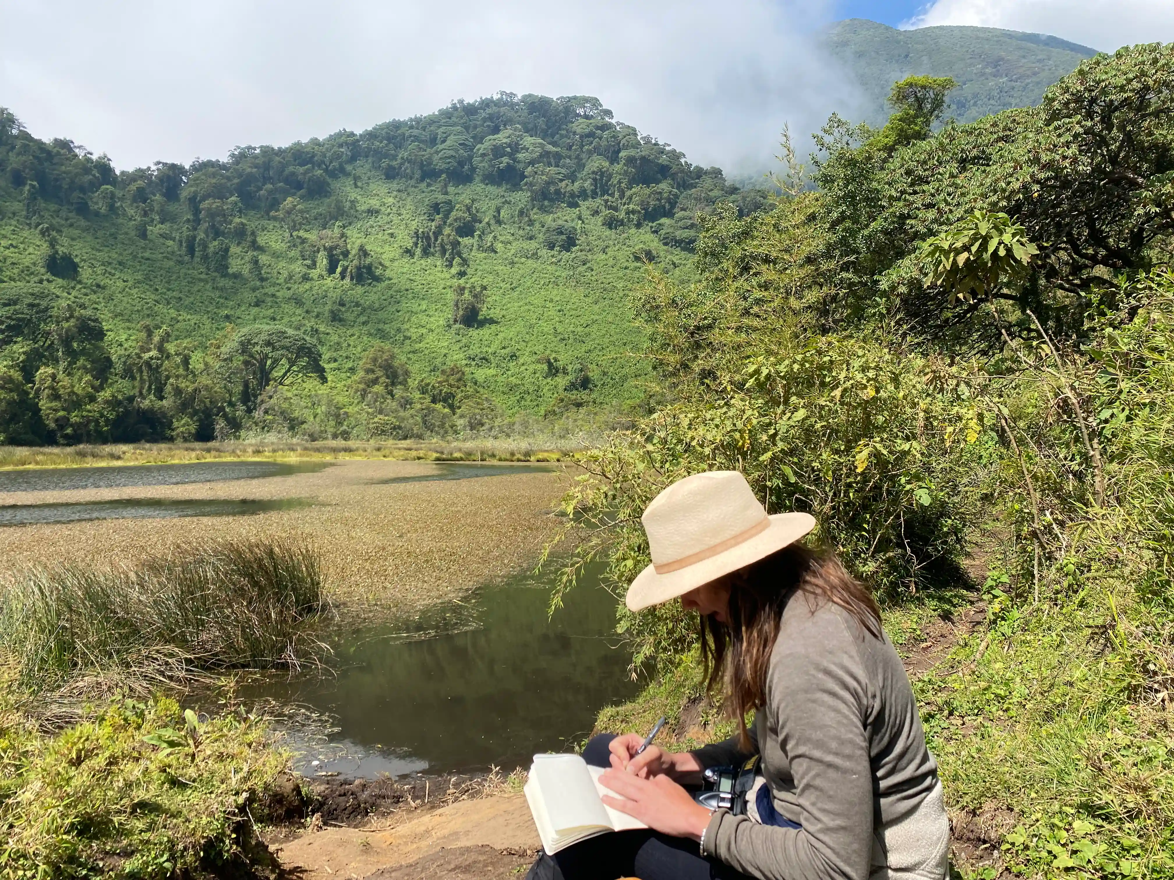 Traveler exploring Ngezi in Volcanoes National Park during one of the 10 best hiking tours and trails in Rwanda, surrounded by lush rainforest and volcanic landscapes.