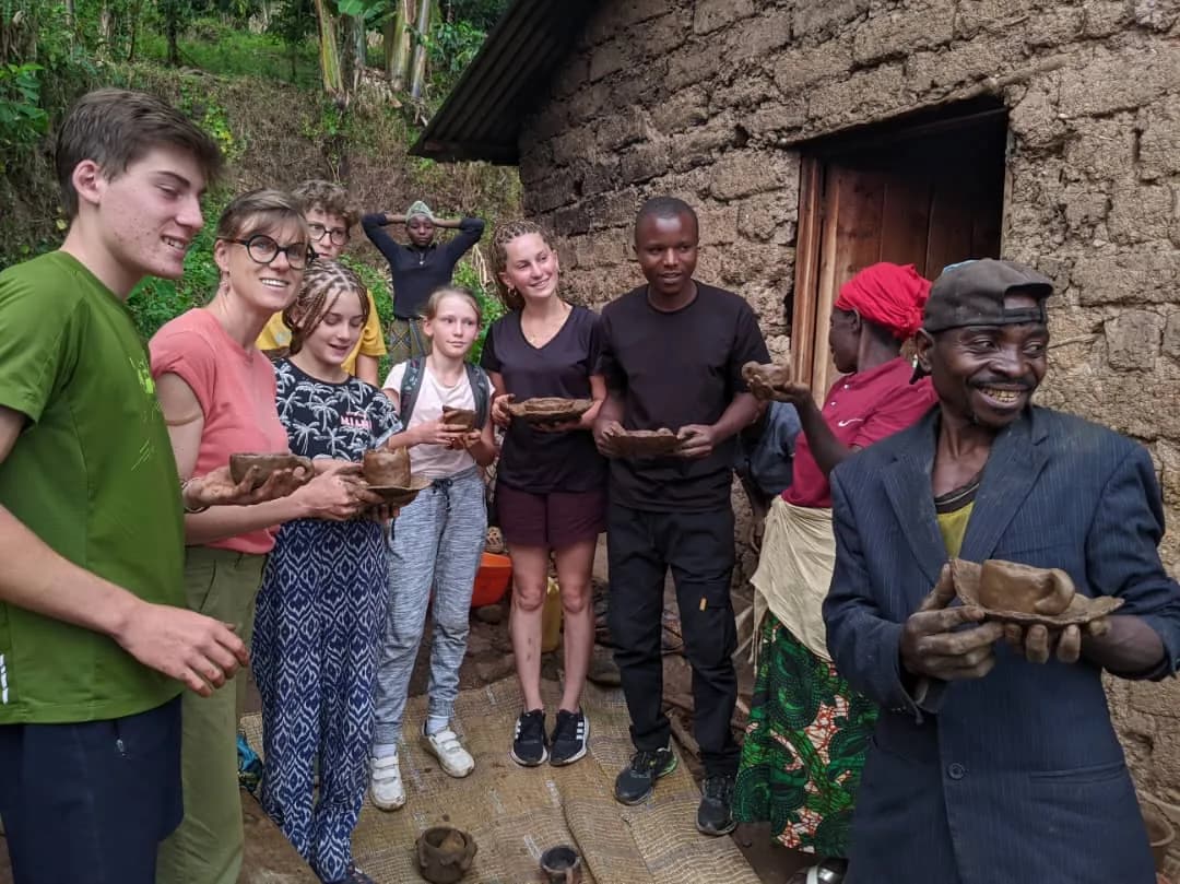 Travelers taking a joyful group photo with local community after a traditional poetry experience in Rwanda.