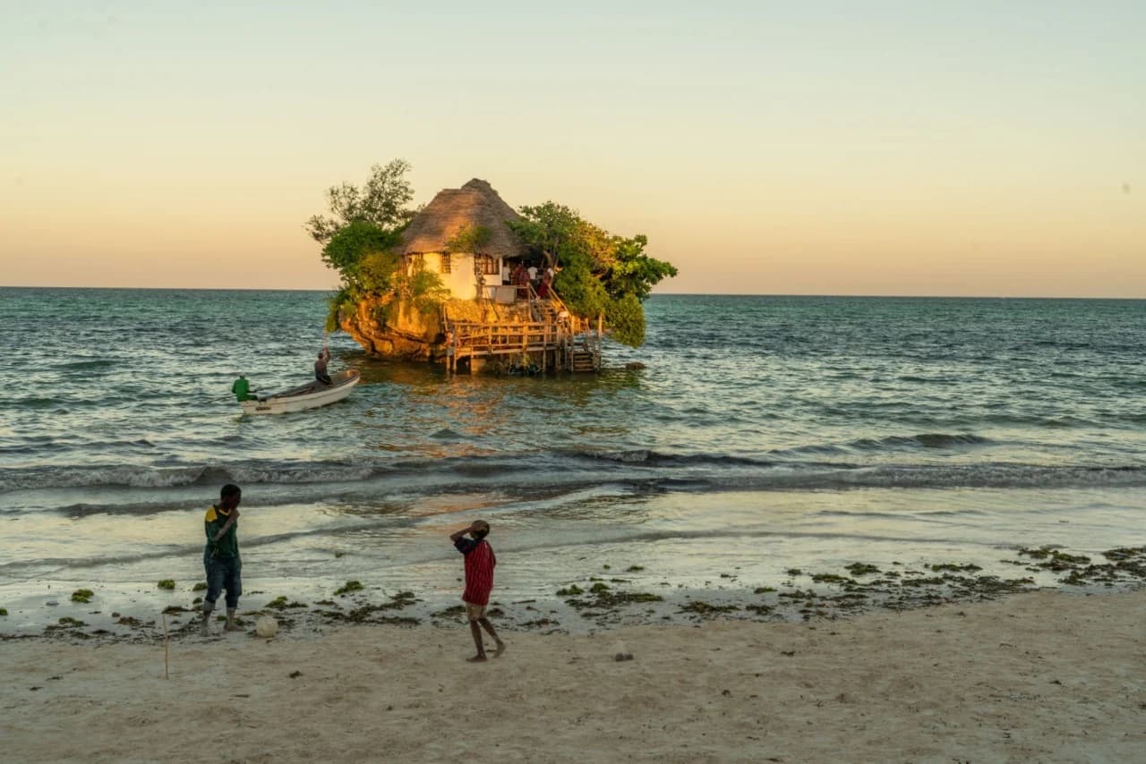Iconic Zanzibar beach restaurant at sunset with wooden deck over turquoise ocean — How To Visit & Experience Zanzibar: Ultimate Travel Guide.
