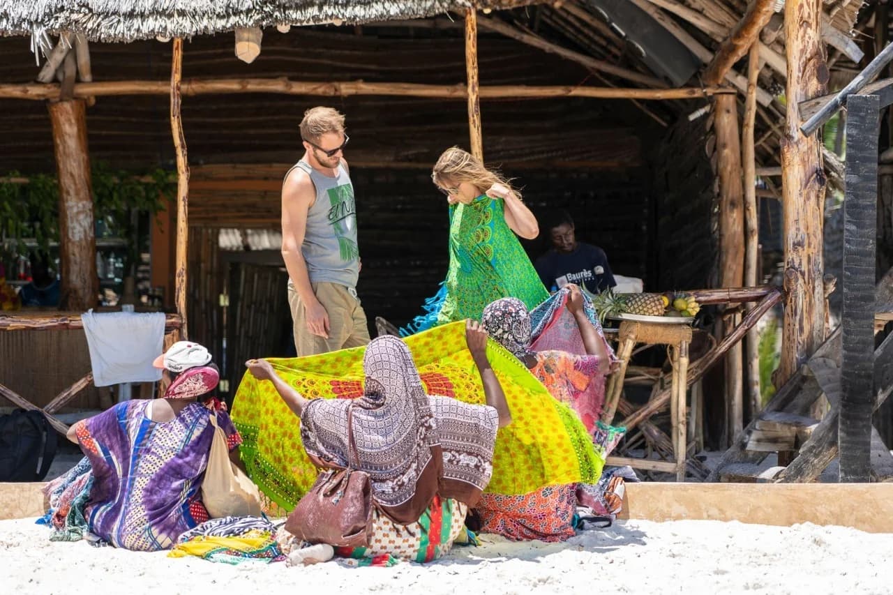 Travelers shopping for handcrafted souvenirs at a vibrant street market in Zanzibar — How To Visit & Experience Zanzibar: Ultimate Travel Guide.