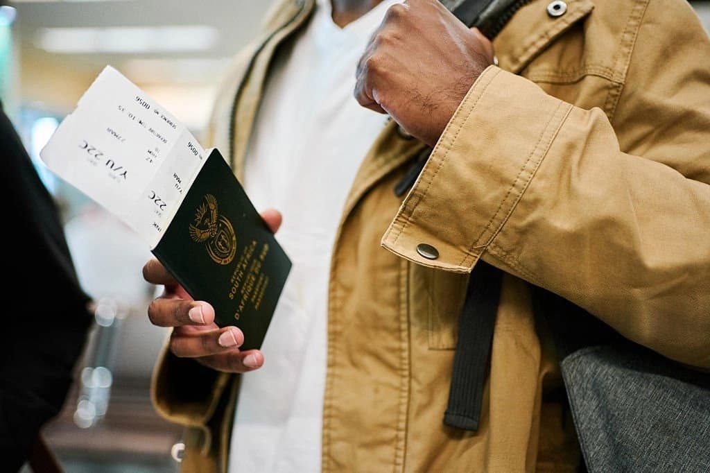 A happy traveler holding a South Africa visa, excited and ready to explore the beauty of South Africa.