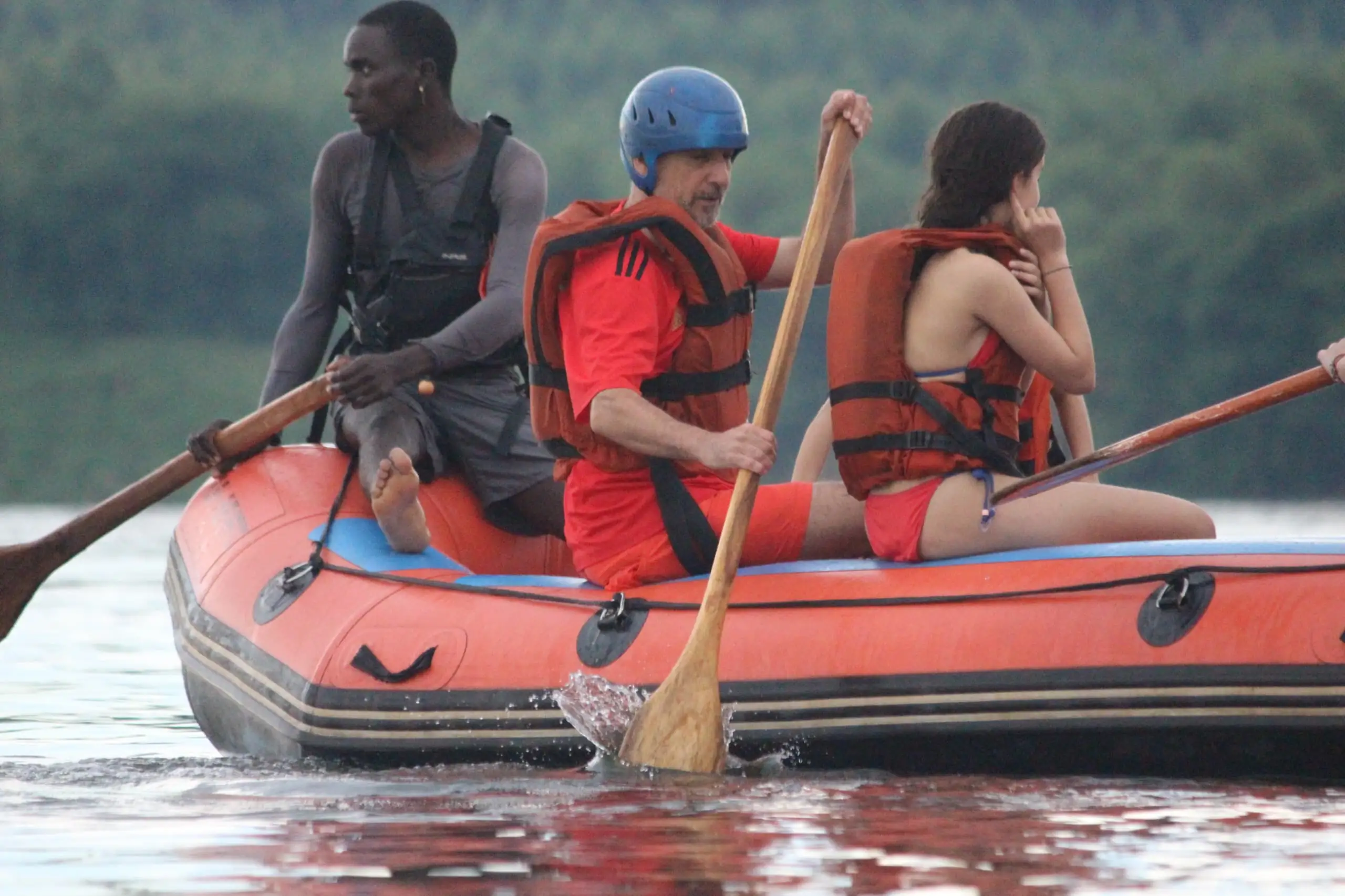 Two travelers rafting on the Nile River in Jinja, Uganda, guided by a local expert during a white-water adventure tour.