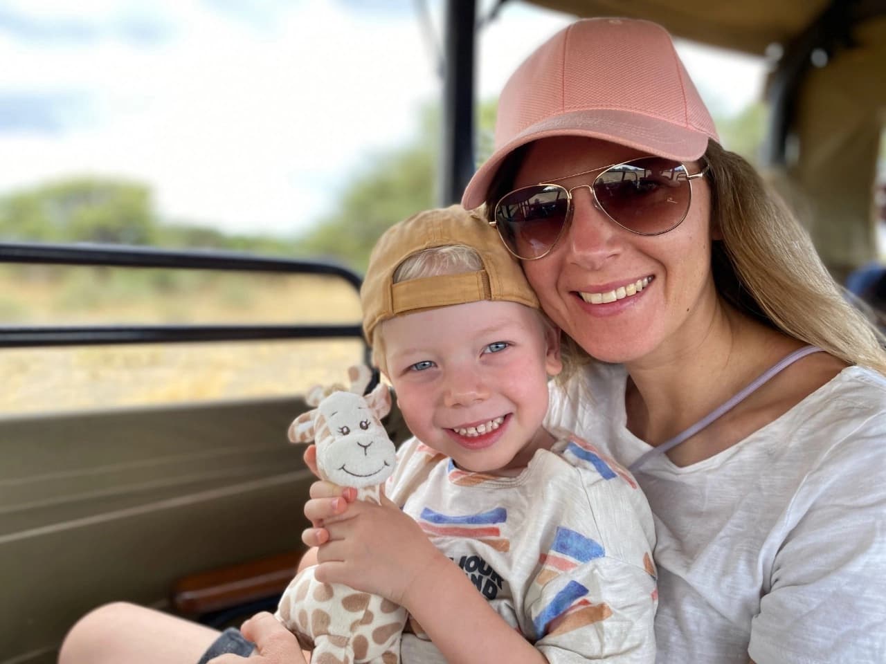 Mother and young child on safari in Ngorongoro Crater smiling as they view wildlife—Best family friendly safari and tours in Tanzania.