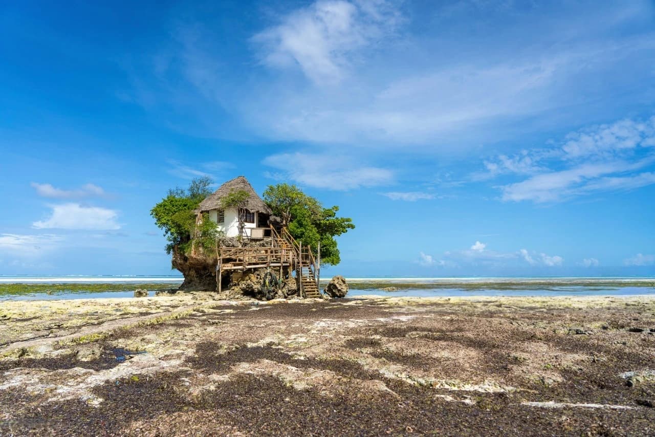 The Rock Restaurant on the beach in Zanzibar, perched above turquoise waves at sunset, showcasing the natural beauty and island charm of a Zanzibar paradise.