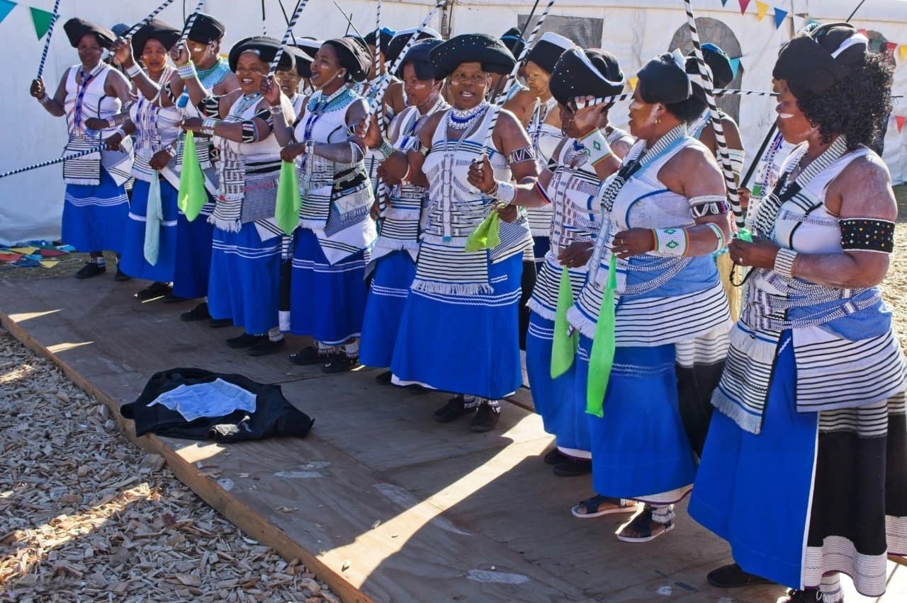 Group of Zulu women performing traditional dance in vibrant tribal attire in South Africa